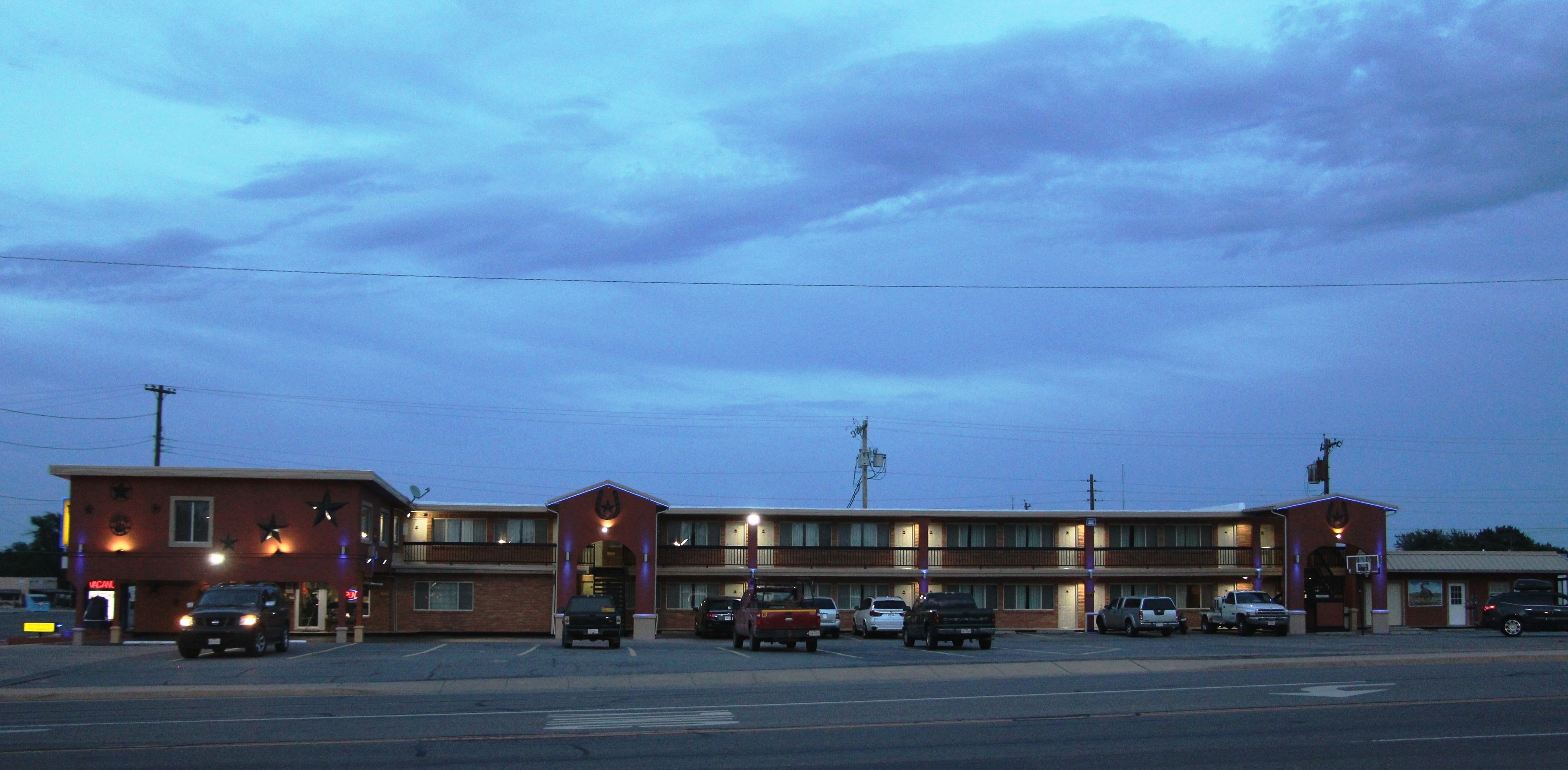 Un motel con diverse camere, un parcheggio e vista sulla strada.