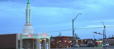 A building with a prominent tower and neon signs, including a gas station with a red neon sign.