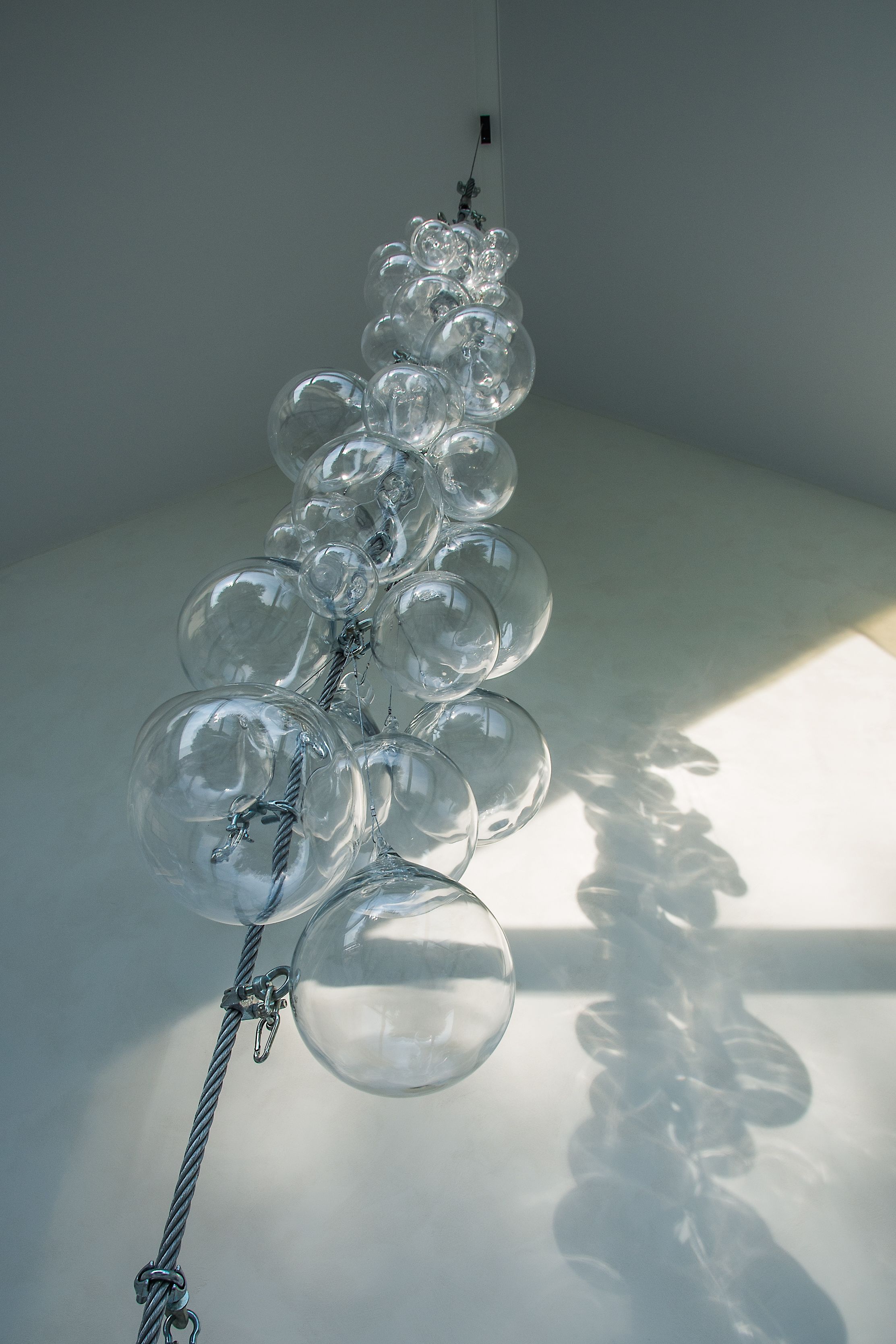A chandelier with clear glass orbs hanging from a twisted metal structure.