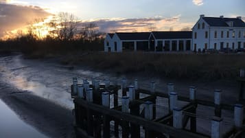Waterfront property with a symmetrical facade and dock overlooking a calm body of water.