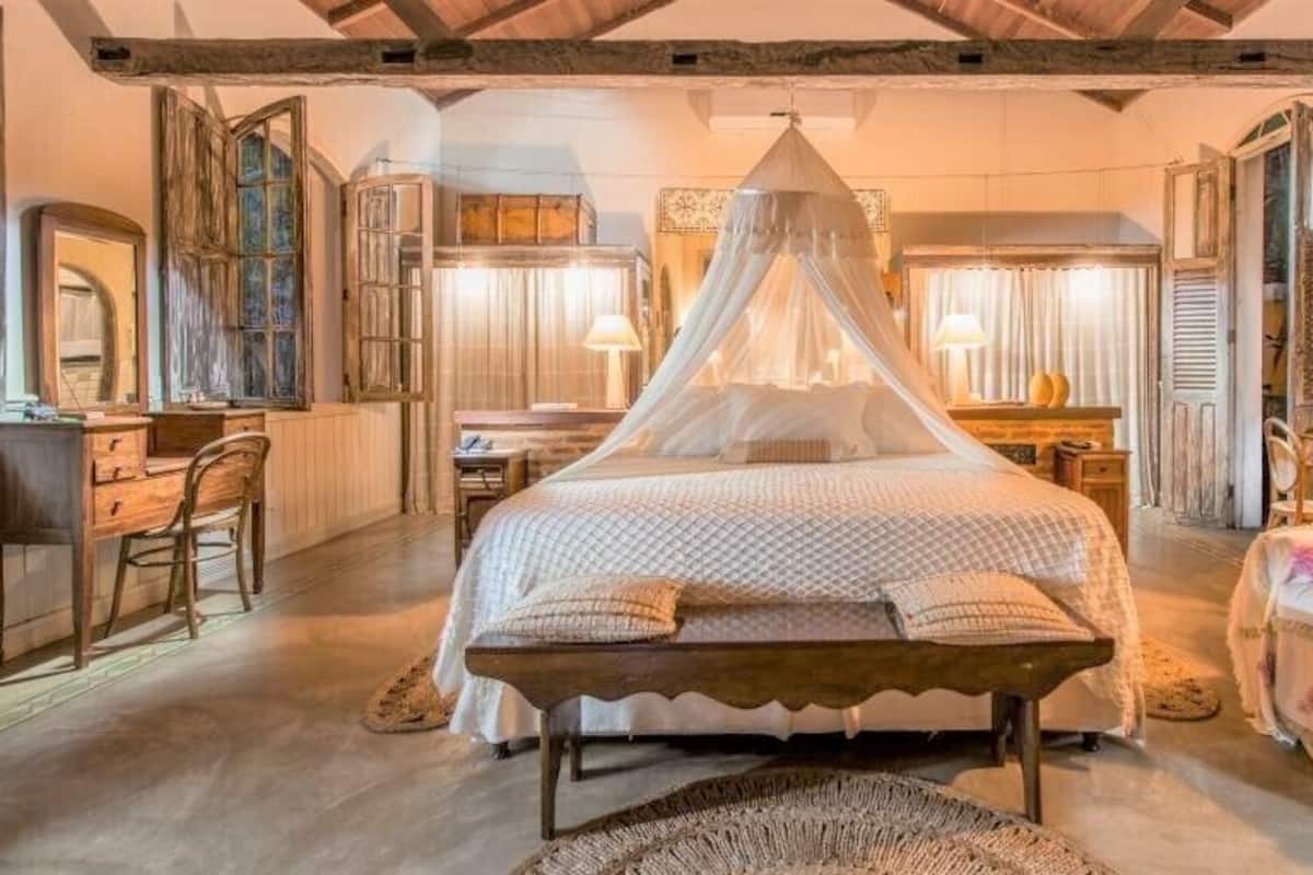 A bedroom with a canopy bed, wooden furniture, and a rustic decor style.