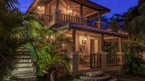 A two-story house with a balcony, surrounded by tropical plants. - Toca da Coruja - Eco Luxury Retreat (Tibau do Sul)