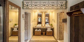 A bathroom with two sinks, large mirrors, wicker baskets, and a wooden door. - Toca da Coruja - Eco Luxury Retreat (Tibau do Sul)