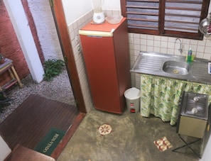 A compact kitchen with a sink, a stove, and a refrigerator. - Hostel Flor de Caju (Tibau do Sul)