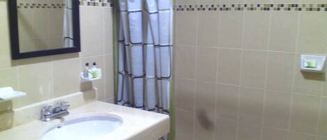 A bathroom with a sink, mirror, and shower curtain.