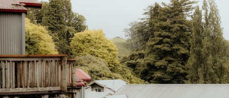 A rural setting with a red and white building, surrounded by tall trees and a hilly landscape.