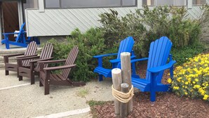 Terrassensitzgelegenheiten mit Adirondack-Stühlen und einem Holzpfosten, an dem ein Seil befestigt ist.