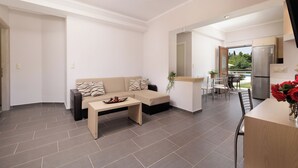 Un salon moderne comprenant un canapé, une table basse et un coin repas avec des chaises et une table.