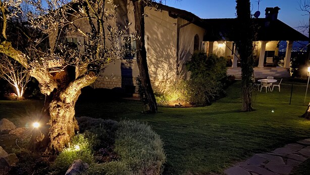 Un sendero de piedra que lleva a un edificio con un área de estar al aire libre y techada.