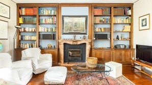 Una sala de estar con chimenea, estanterías, televisor y sofá.