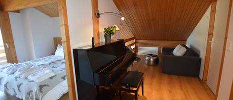 Une chambre à coucher avec un piano, un canapé et un lit.