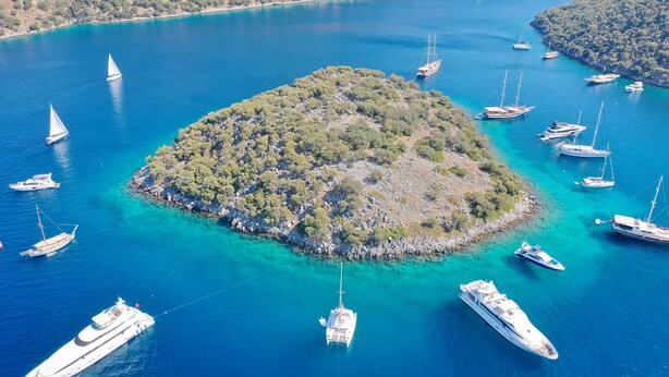 An aerial view of a small island surrounded by clear blue waters with several yachts anchored around it. - Calis Beach - Beautiful 4 bedroom villa with private pool and WiFi  (Fethiye)