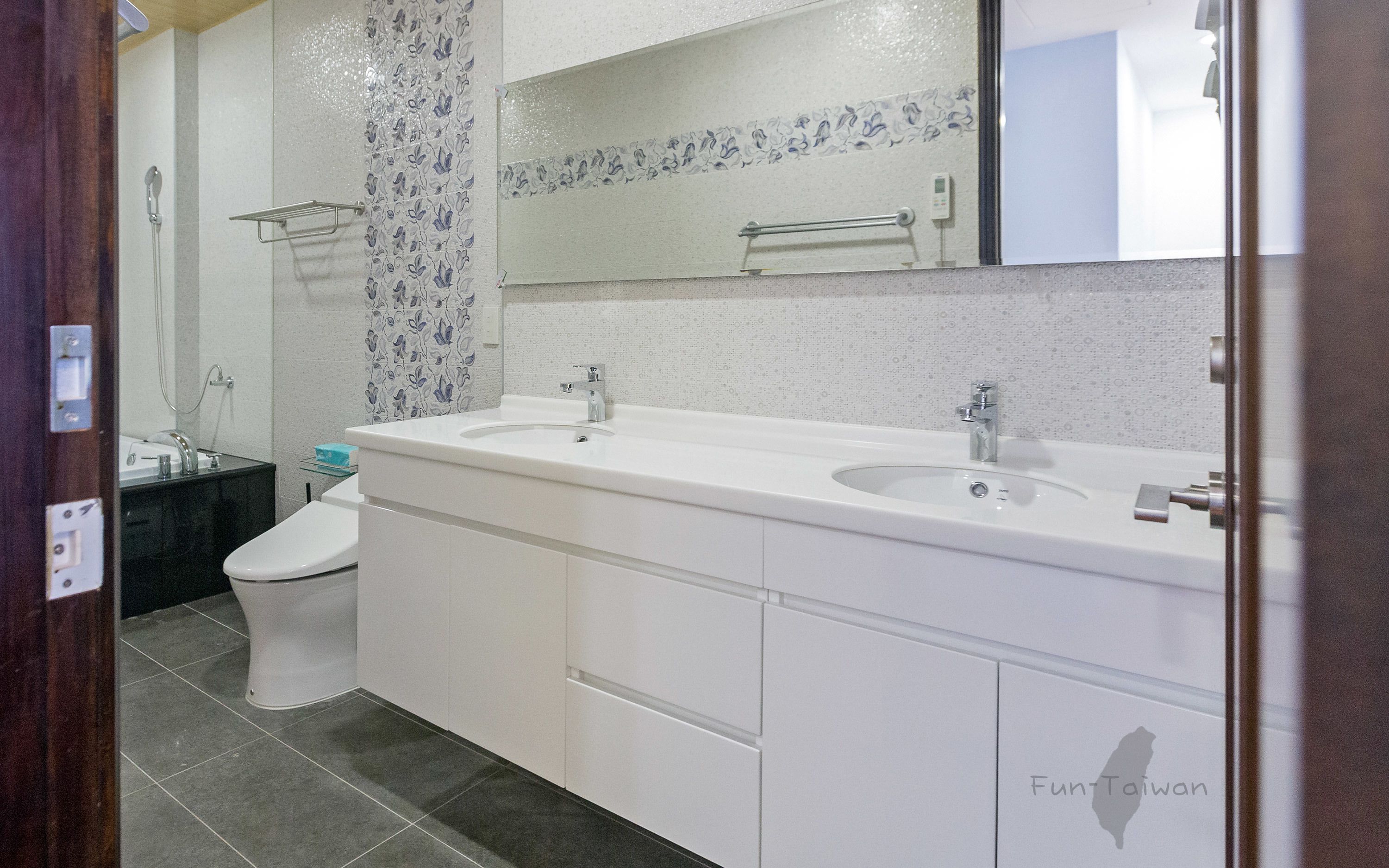 A bathroom with two sinks, a toilet, and a shower.
