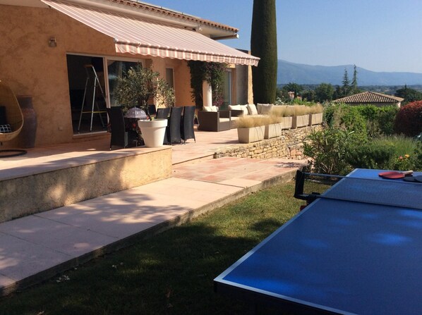 A patio area with outdoor seating, a ping pong table, and a view of distant mountains. - Villa with Pool in a private domain in Valbonne - (Valbonne)