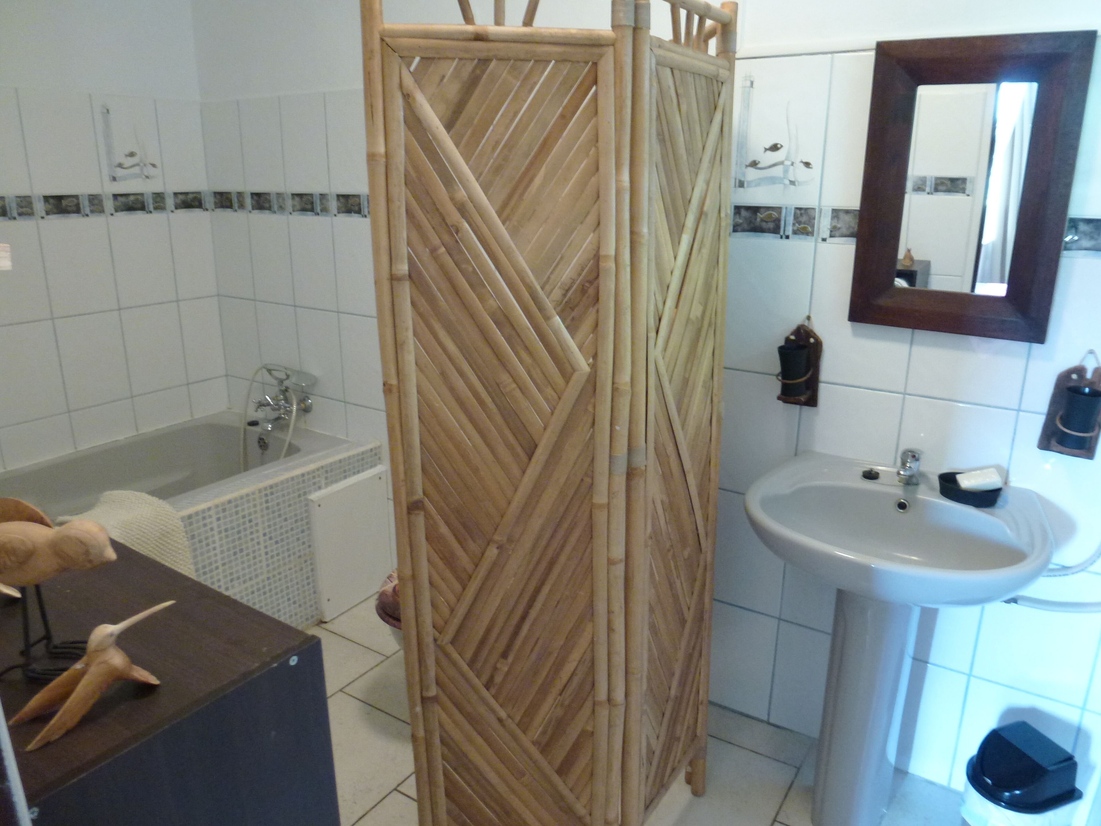 Un baño con bañera, lavamanos y espejo.