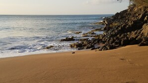 A beach with a rocky shoreline and a clear view of the ocean. - The KREYOL LODGES presents its SUITE KAYOU ... view sea and mountain (DESHAIES)