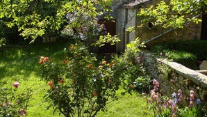 Un jardin agrémenté de différentes sortes de fleurs et doté d’un mur en pierre.