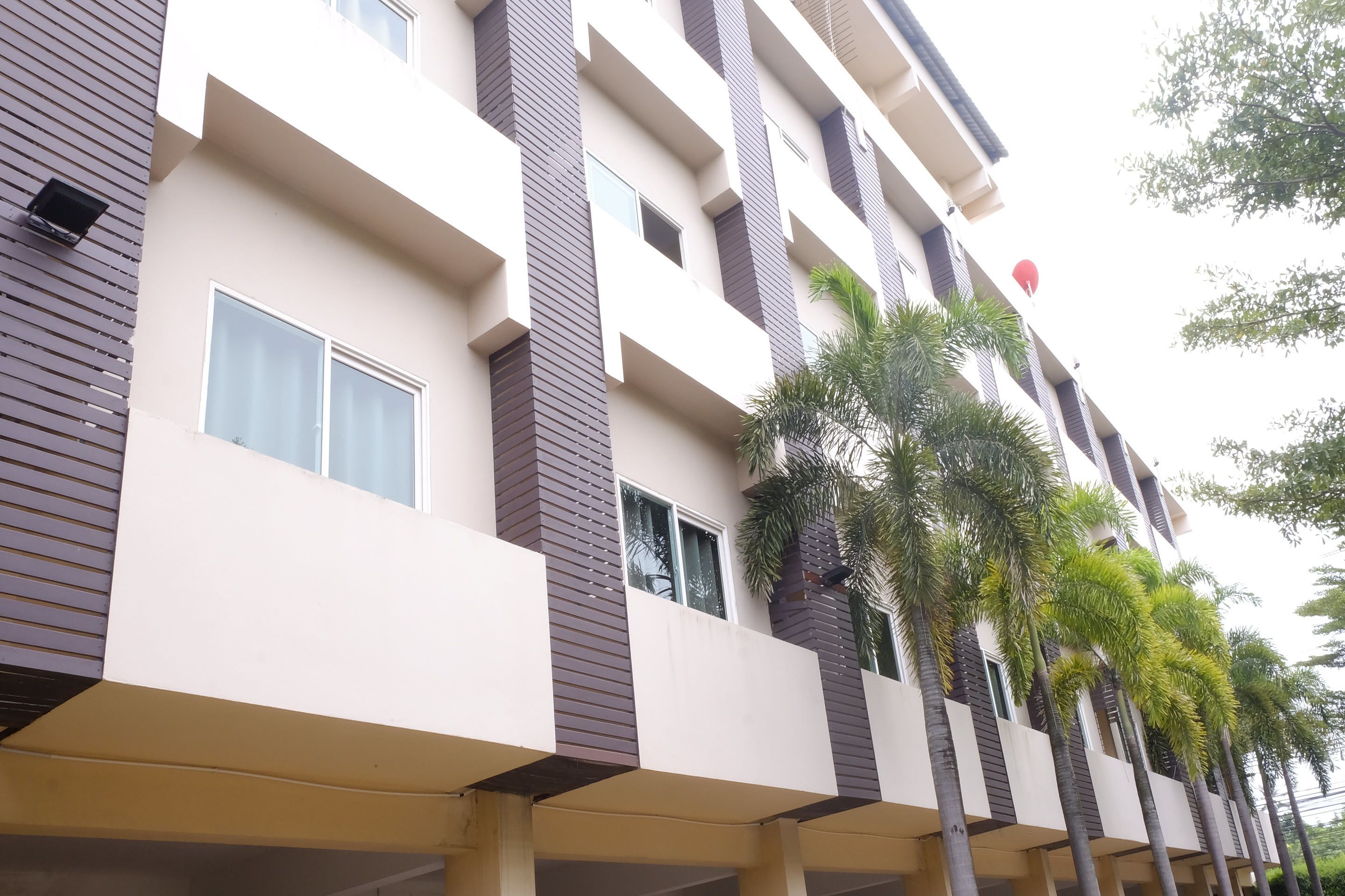 A multi-story building with a modern architectural design, featuring balconies and a series of windows.