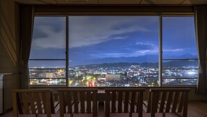 Una habitación con un ventanal grande que da a una vista nocturna de la ciudad.