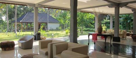 A spacious indoor area with a large open space, a dining table, and several sofas.