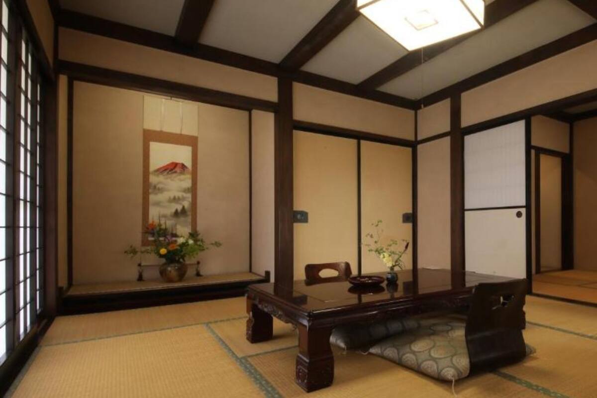 A traditional Japanese room with tatami flooring, a low wooden table, and a sliding door.