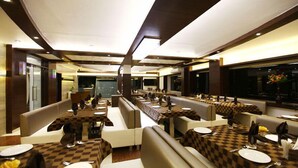 Un restaurante moderno con una barra larga, cabinas y mesas.