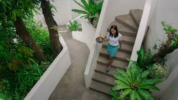 A person descending a concrete staircase surrounded by lush greenery.