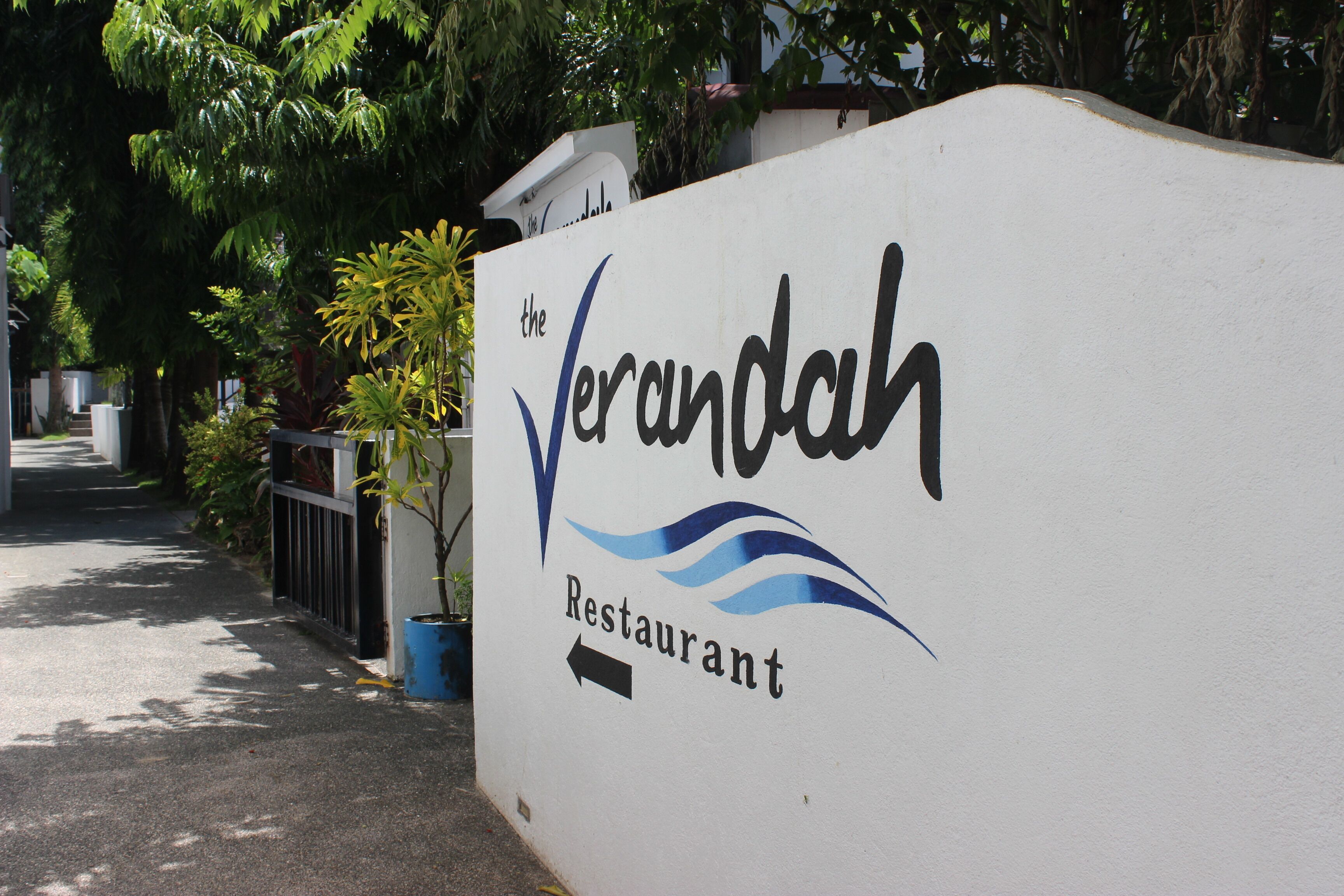 Un panneau indiquant « The Verandah Restaurant » avec une flèche directionnelle.