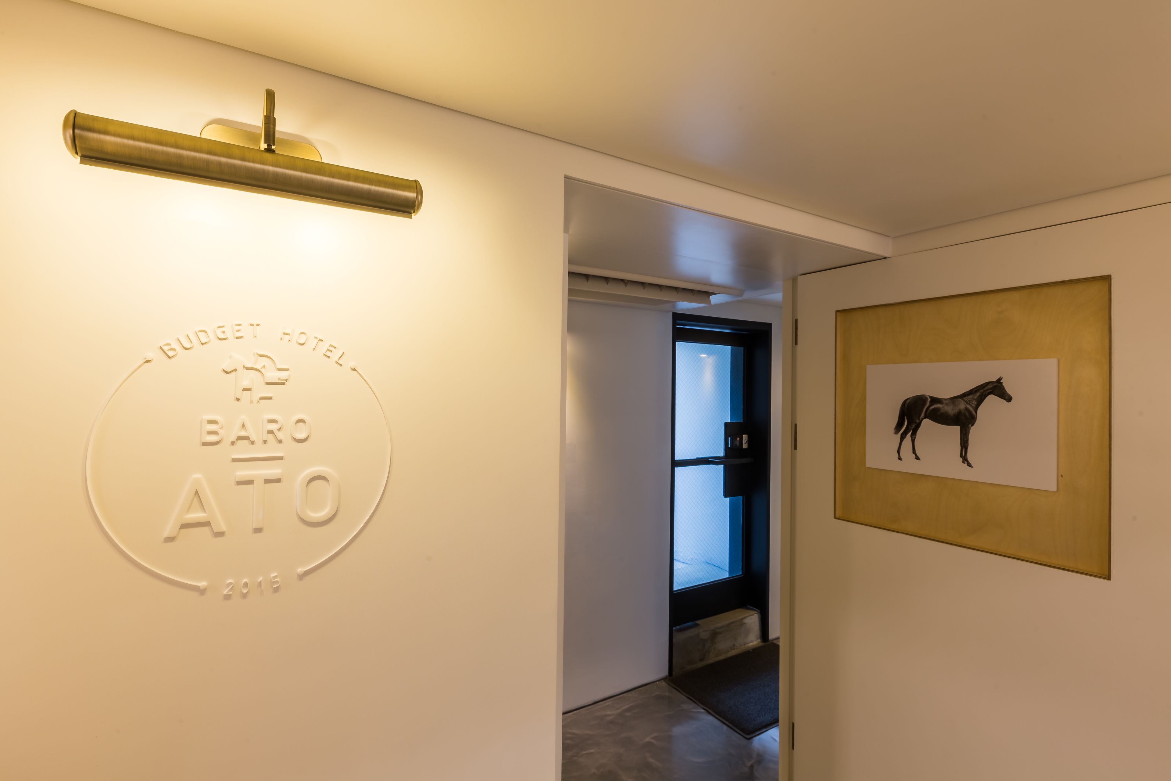 Entrada de un hotel con un cartel que dice "Budget Hotel Baro ATO 2015".