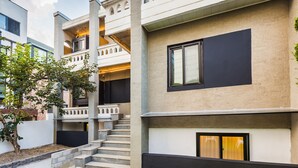 A multi-story residential building with a modern design, featuring a staircase leading to a balcony, and a flat entrance with a door. - BAROATO 2nd (Seoul)