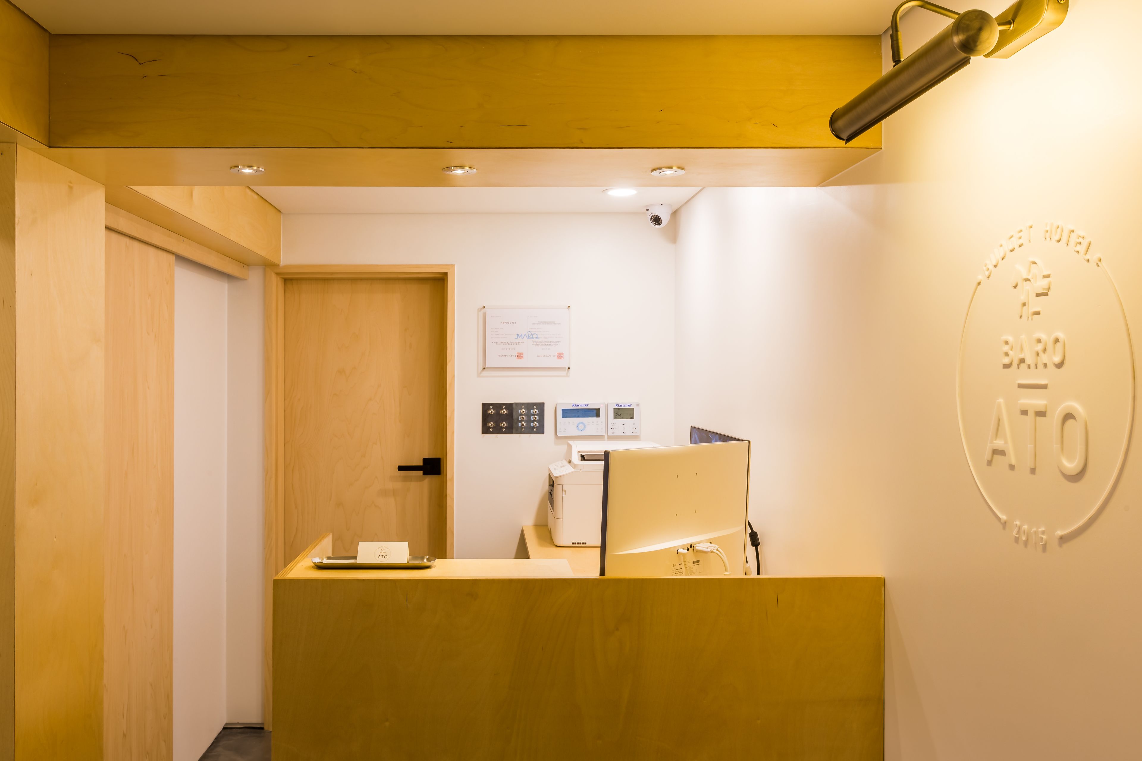 A reception desk with a computer, a wall-mounted sign, and a door.