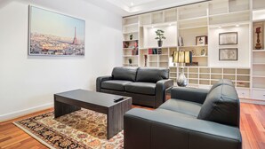 Una sala moderna con un sofá, una mesa de centro y una estantería.