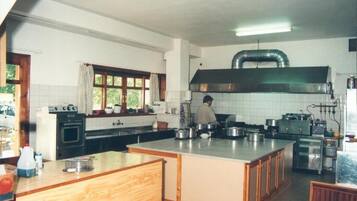 A spacious kitchen with a large island, a built-in oven, and a range hood.