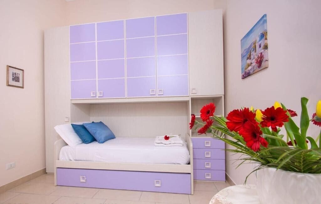 Ein Schlafzimmer mit einem Bett, einem Kleiderschrank und einem Wandregal.