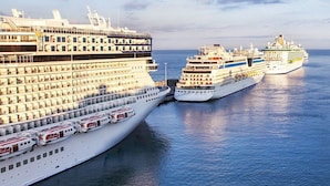 Un gran crucero atracado en un puerto, con varios cubiertas y camarotes visibles.