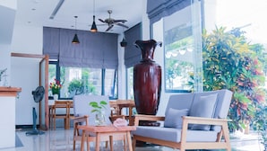 A modern living room with a large vase, a sofa, and a dining area with wooden furniture.