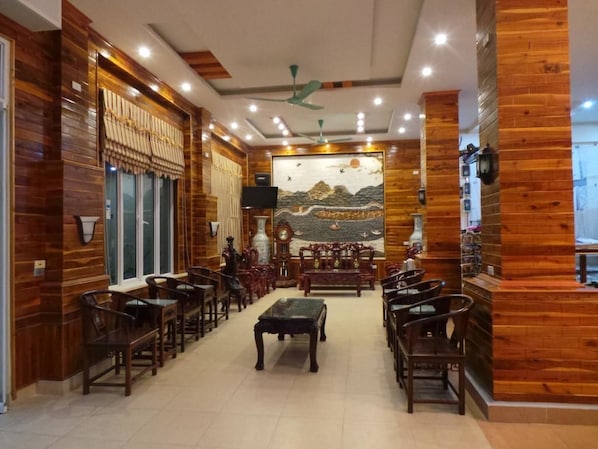 A spacious lobby with wooden paneling, a central seating area, and a mural on the back wall.