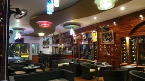Un espace bar avec des sièges, un comptoir et diverses bouteilles et verres.