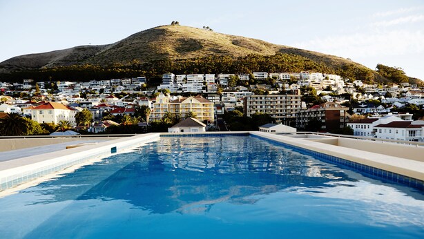 Une piscine avec vue sur un quartier résidentiel situé sur une colline.