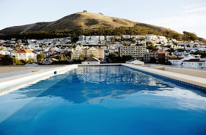 A swimming pool with a view of a hillside residential area.