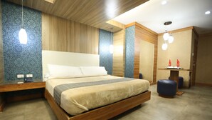 A modern bedroom with a wooden bed frame, a nightstand, a blue patterned wall, and a wooden ceiling. - Victoria Court Canley - Pasig (Pasig)
