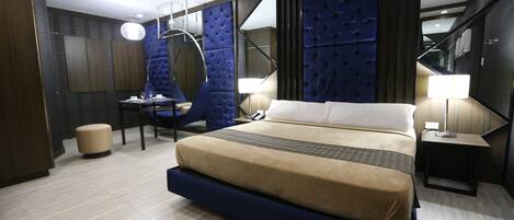 Una habitación de hotel moderna con una cama grande, un escritorio y una silla.