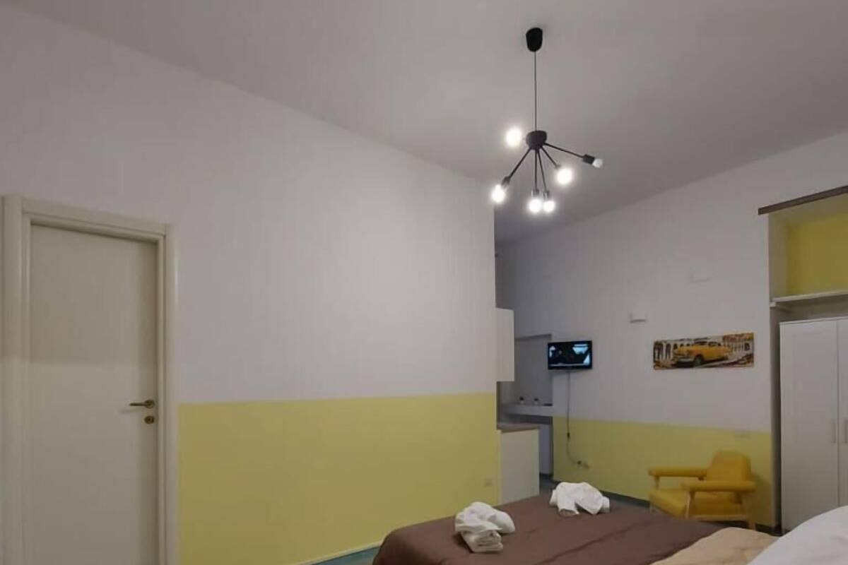 Un dormitorio con cama, escritorio, silla y televisor.