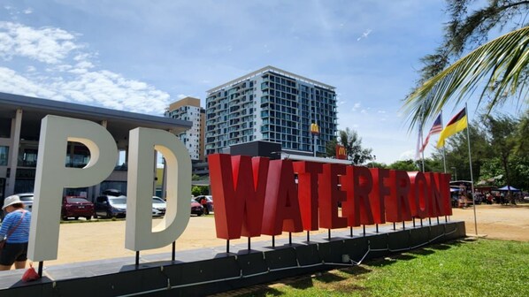 Un cartel con la inscripción 'PD WATERFRON' y el logotipo de McDonald's, que indica una ubicación cerca de la zona costera.