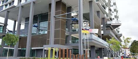 A modern hotel building with a prominent sign reading "Dihlart Hotel & Serviced Residence."