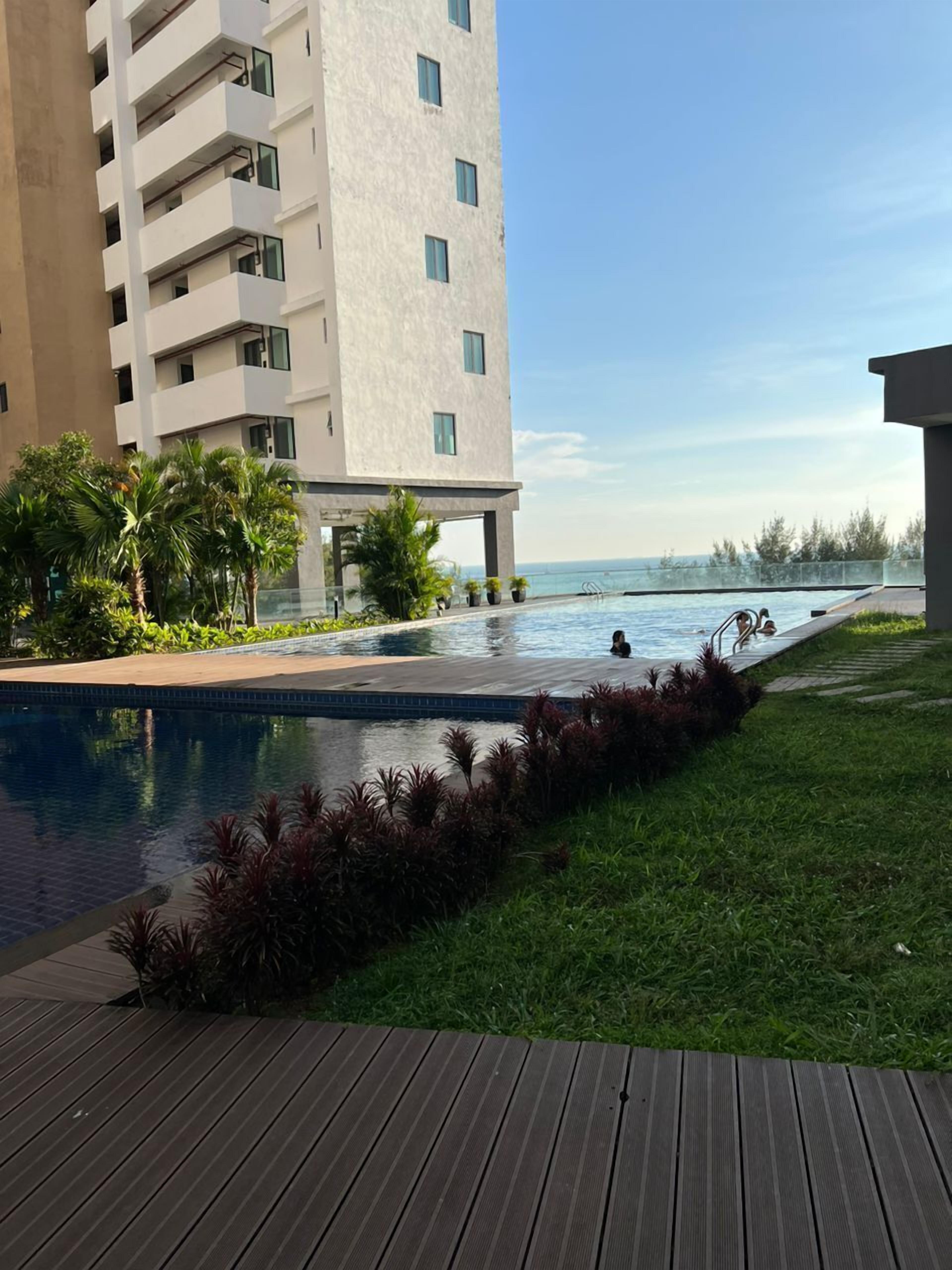 A modern building with a pool and a view of the ocean.