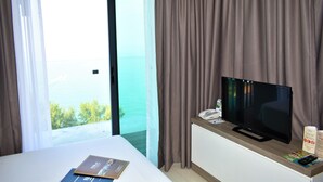 A hotel room with a bed, a television on a wooden console, a remote control, and a brochure on the bed. - D'Wharf Hotel & Serviced Residence (Port Dickson)