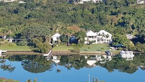 A lakeside property with multiple houses, a golf course, and a dock. - Riverview Guesthouse (East London)