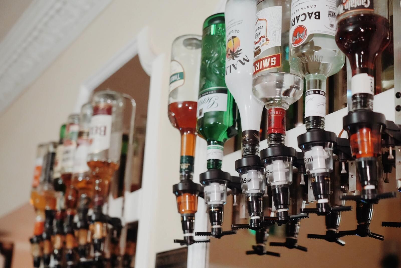 A row of alcohol dispensers with various bottles.