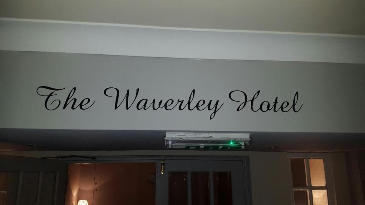 Una pared con el texto "The Waverley Hotel" en una tipografía decorativa.